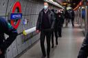 A man wears a mask while travelling on the London Underground