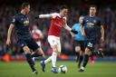 Arsenal's Mesut Ozil (centre) battles for the ball with Manchester United's Nemanja Matic (left) and Diogo Dalot during the Premier League match at the Emirates Stadium, London.