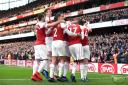 Arsenal's Pierre-Emerick Aubameyang (obscured) celebrates scoring his side's first goal of the game from the penalty spot with team-mates, as a banana skin is thrown onto the pitch by a fan, during the Premier League match at Emirates Stadium, London. PA