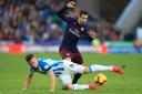 Huddersfield Town's Jonathan Hogg (left) and Arsenal's Henrikh Mkhitaryan battle for the ball during the Premier League match at the John Smith's Stadium, Huddersfield. PA