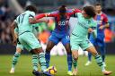 Arsenal's Alex Iwobi (left) and Matteo Guendouzi (right) battle for the ball with Crystal Palace's Wilfried Zaha (centre) during the Premier League match at Selhurst Park, London.
