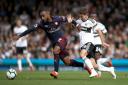 Arsenal's Alexandre Lacazette (left) and Fulham's Luciano Vietto battle for the ball during the Premier League match at Craven Cottage, London.