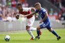 Arsenal's Pierre-Emerick Aubameyang (left) and Cardiff City's Joe Bennett battle for the ball during the Premier League match at the Cardiff City Stadium.