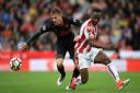 Arsenal's Aaron Ramsey (left) and Stoke City's Saido Berahino battle for the ball (pic Mike Egerton/PA)