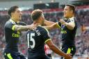 Arsenal's Alexis Sanchez (right) celebrates scoring his side's first goal of the game with team mates during the Premier League match at the Stadium of Light, Sunderland.