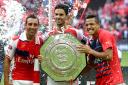 Arsenal's new captain Mikel Arteta (centre) shows off the Community Shield trophy with Santi Cazorla and Alexis Sanchez