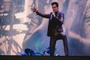 Brandon Flowers poses on stage as The Killers play at the Emirates