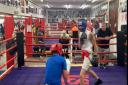 Coach Roy Callaghan oversees sparring in one ring whilst Lenny Hagland supervises the other at Islington Boxing Club