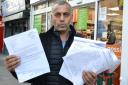 Turabi Keskin outside his Londis shop in Hornsey Road with some of the 400 signatures in favour of granting him an Oyster top-up point. Picture: Polly Hancock