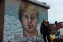 Claudia Hicks stands in front of the finished mural of her brother Henry who died aged 18