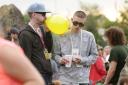 Festivalgoers inhale gas from a balloon