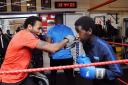 Coach and former boxer Jermaine Williams (left) doing pads with Kevin Ozee, 15. Picture: Dieter Perry
