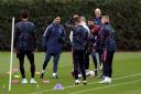 Mikel Arteta shares a joke with Arsenal players during a training session