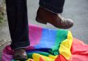 A person stamping on an LGBT pride flag