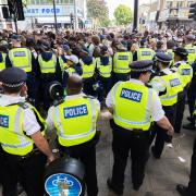 Police arrive as crowds of people wait outside the entrance to Wireless Festival at Finsbury Park on July 10