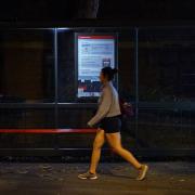 A woman walking alone after dark past a bus stop on Poynders Road in Clapham, south London, close to where Sarah Everard was abducted from the street after being falsely arrested by police officer Wayne Couzens