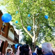A crowd of Tony's friends, family and customers release blue balloons in Tony's honour.