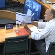 Dominic Cummings, former chief adviser to Prime Minister Boris Johnson, holds up a document whilst giving evidence to a joint inquiry of the Commons Health and Social Care and Science and Technology Committees on coronavirus