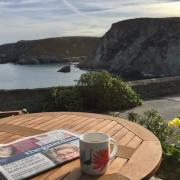 Enjoying the Saturday papers and a cup of coffee outside Pier Cot. Picture: Emma Bartholomew
