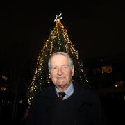 Former Arsenal captain Frank McLintock in front of the Highbury Square Christmas tree