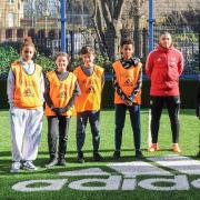 Coach Kai Brennan and young people at the refurbished Harvist Estate pitch